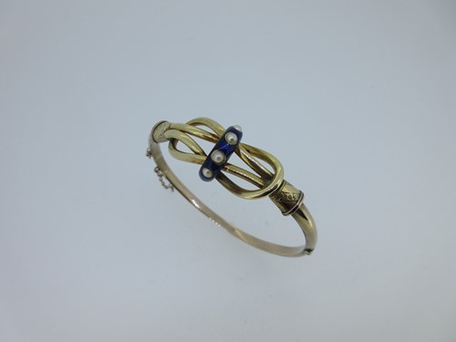 Lot 158 - A Victorian hinged bangle with enamel and seed pearl centre