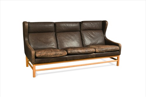 Lot 218 - In the manner of Borge Mogensen and possibly by Eric Jorgensen, a Danish brown leather wing-back three-seat sofa