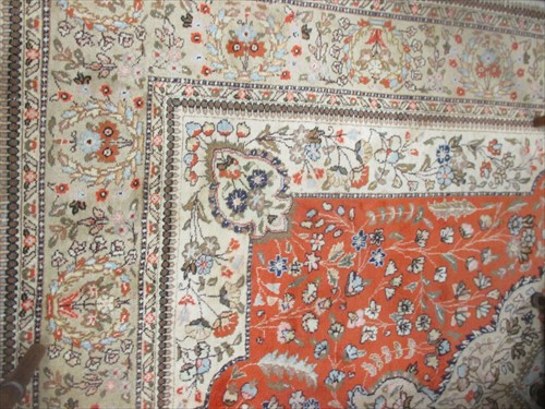 Lot 667 - A modern cream and rust ground rug with floral...