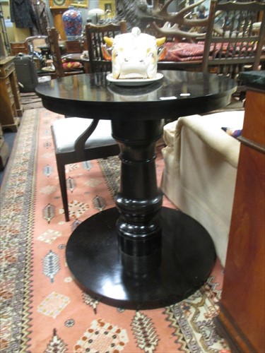 Lot 535 - An ebonised pedestal table with circular top...