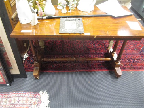 Lot 583 - A rosewood writing table on twin turned end...