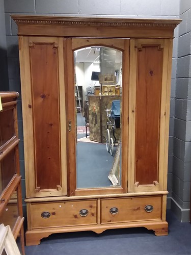 Lot 482 - A stripped pine wardrobe, with central arched...