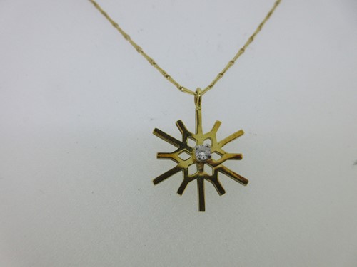 Lot 14 - An 18ct gold diamond set snowflake pendant