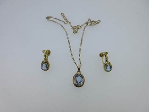 Lot 120 - A blue spinel pendant set in gold and a matched pair of earpendants