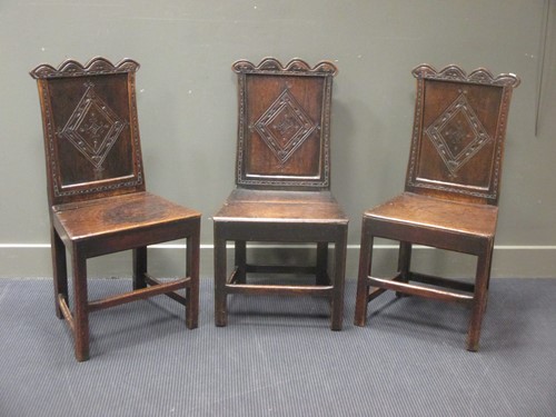 Lot 494 - Three oak wave back oak dining chairs in 17th...