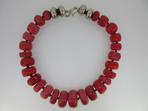 Lot 43 - A vintage necklace of large coral beads with double bun white metal beads