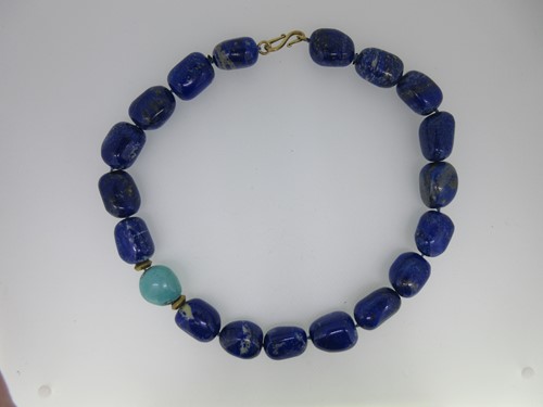 Lot 84 - A necklace of large lapis lazuli beads and one turquoise