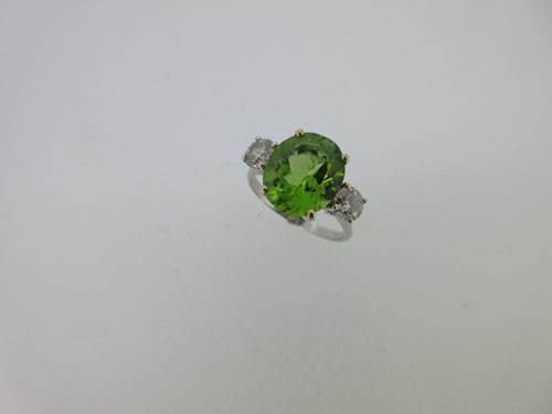Lot 213 - A peridot and diamond three stone ring