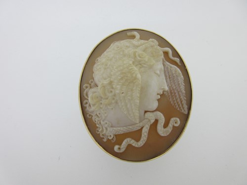 Lot 110 - A shell cameo brooch depicting the head of a classical goddess, possibly one of the Furies
