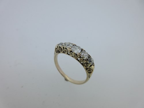 Lot 70 - A five stone diamond ring in carved head mount