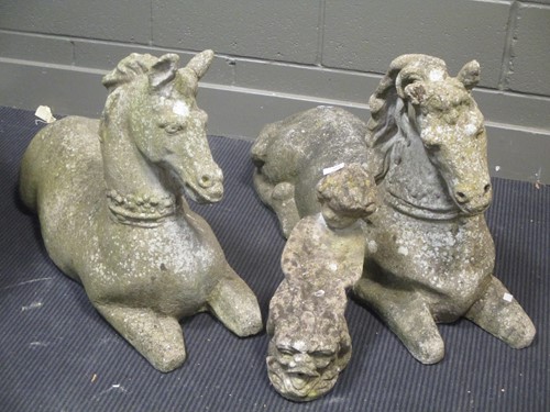 Lot 896 - A pair of recumbent reconstituted stone horse...