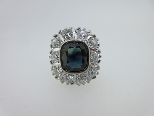 Lot 267 - An 18ct gold sapphire and diamond cluster ring, (one diamond with trigon)