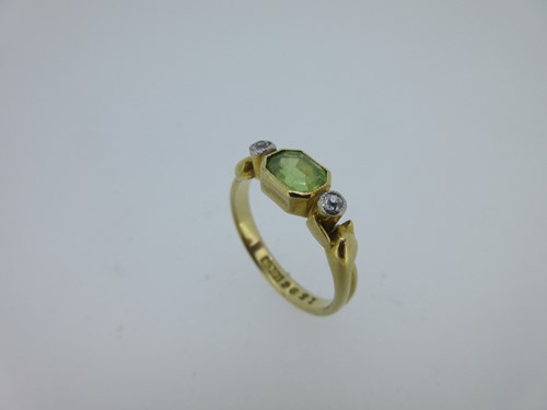 Lot 30 - A peridot and diamond three stone ring with serpent mount