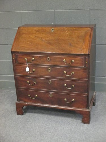 Lot 505 - A George III solid mahogany slope front bureau...