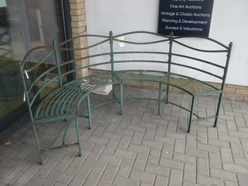 Lot 403 - A curved green painted metal garden bench,...