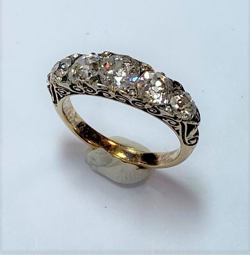 Lot 191 - A five stone carved head style ring