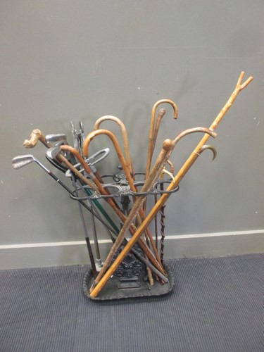Lot 487 - A cast iron stick stand containing assorted...