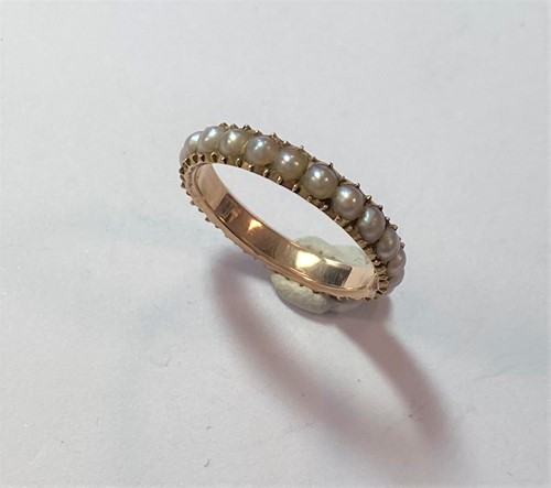 Lot 73 - A full hoop half pearl eternity ring