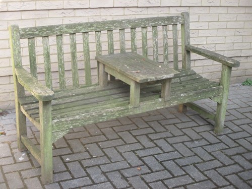 Lot 497 - A teak garden bench with central table