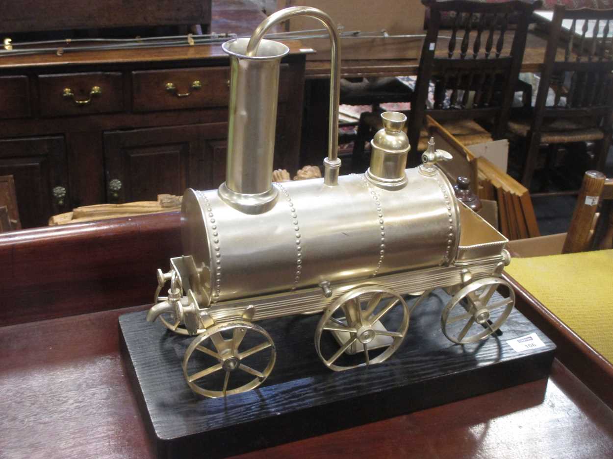 Lot 106 - A silver coloured novelty locomotive shape urn...