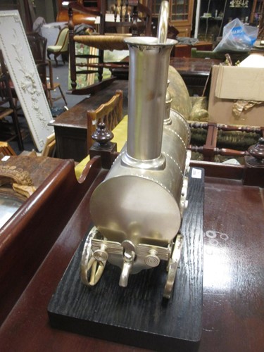 Lot 106 - A silver coloured novelty locomotive shape urn...