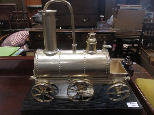 Lot 106 - A silver coloured novelty locomotive shape urn...