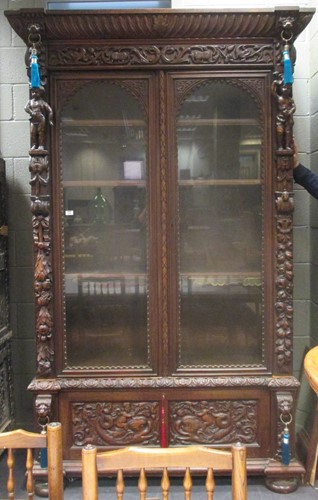 Lot 469 - A carved oak glazed cupboard, 248 x 152 x 56cm