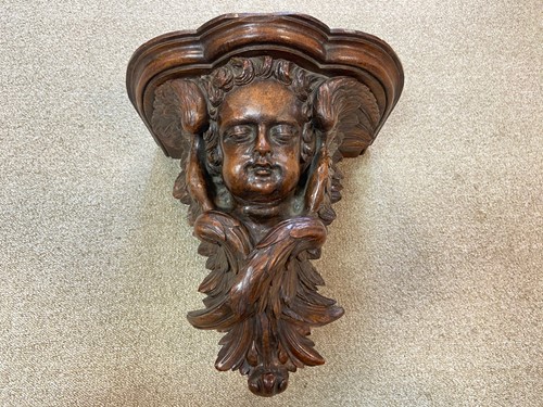 Lot 495 - A carved walnut cherub mask wall bracket, probably 18th century