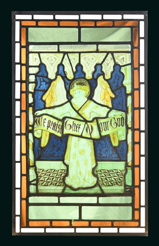 Lot 403 - A 19th century stained glass panel of an angel holding a banner 'We praise Thee O our God'