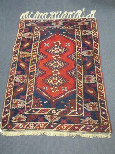 Lot 556 - A Turkish blue and red rug with ivory tassels, 206 x 130cm