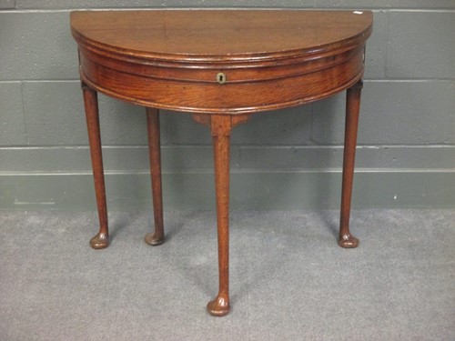 Lot 510 - A mid 18th century oak demi-lune tea table...