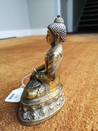 Lot 187 - A 19th century Tibetan gilt bronze model of Buddha
