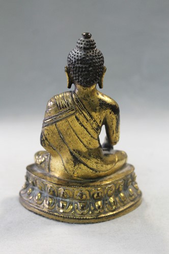 Lot 187 - A 19th century Tibetan gilt bronze model of Buddha