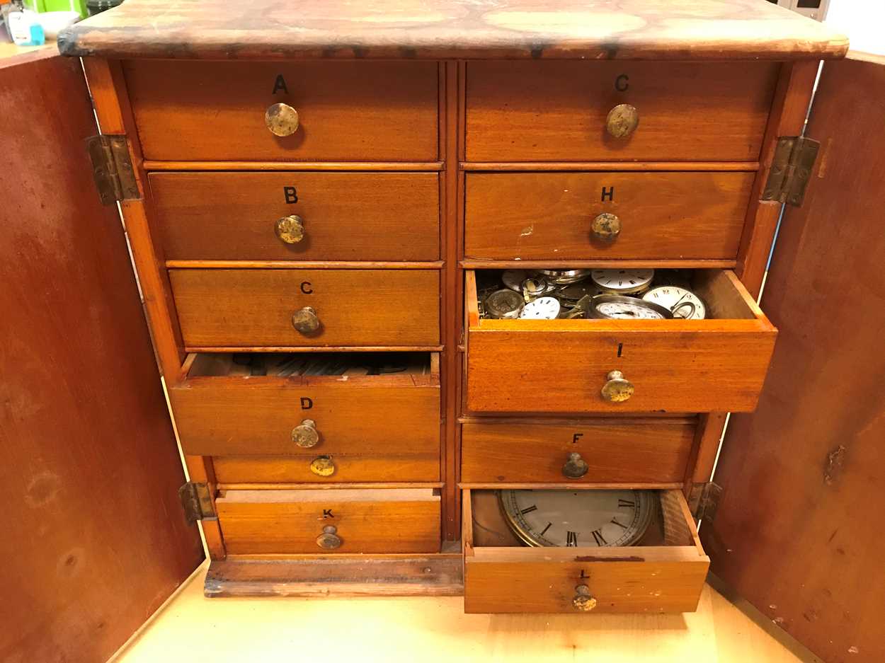 Lot 54 - A cabinet of watchmaker's spare parts, watch...