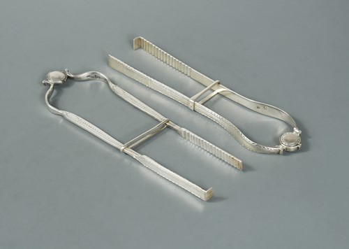 Lot 478 - Two pairs of George III silver sandwich serving tongs