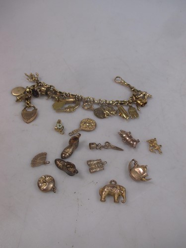 Lot 155 - A charm bracelet marked '9ct' with a quantity...