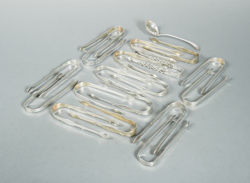 Lot 516 - Seventeen pairs of George III silver sugar nips, a pair of sugar tongs and a sifting spoon by the Batemans