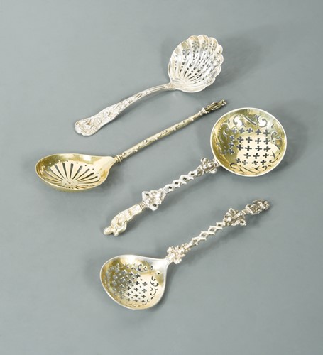 Lot 584 - A collection of four Victorian silver novelty sugar sifting spoons