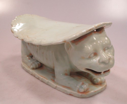 Lot 26 - A Chinese green glazed head rest with feline...