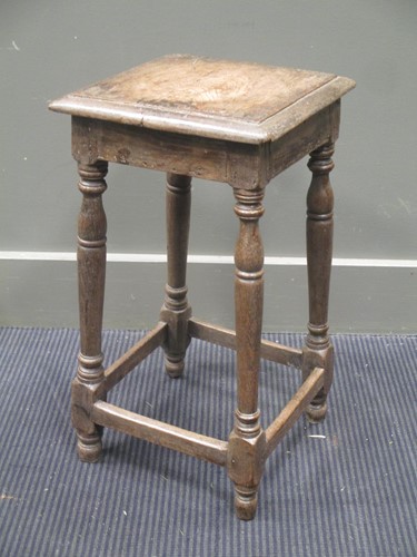 Lot 395 - An 18th century oak stool, the square top over...