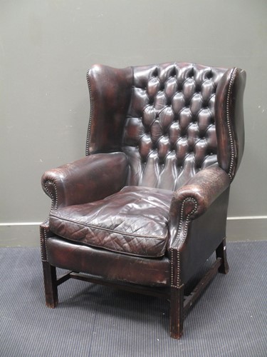 Lot 658 - A George III style leather wing back armchair