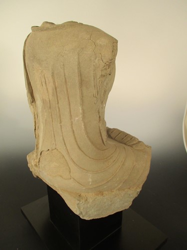 Lot 142 - A Chinese limestone seated Buddha, headless, perhaps Northern Wei Dynasty