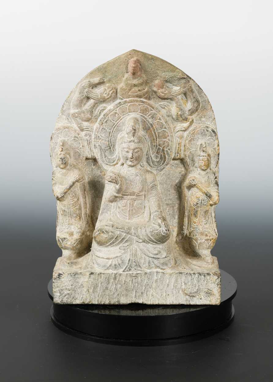 Lot 243 - A Chinese grey stone Buddhist triad stele with aureole, in Wei Dynasty style