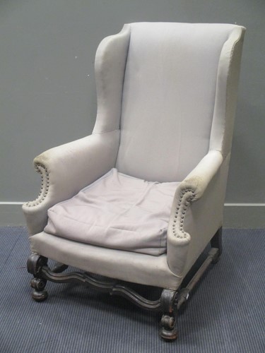 Lot 480 - A grey covered wing armchair on shaped legs