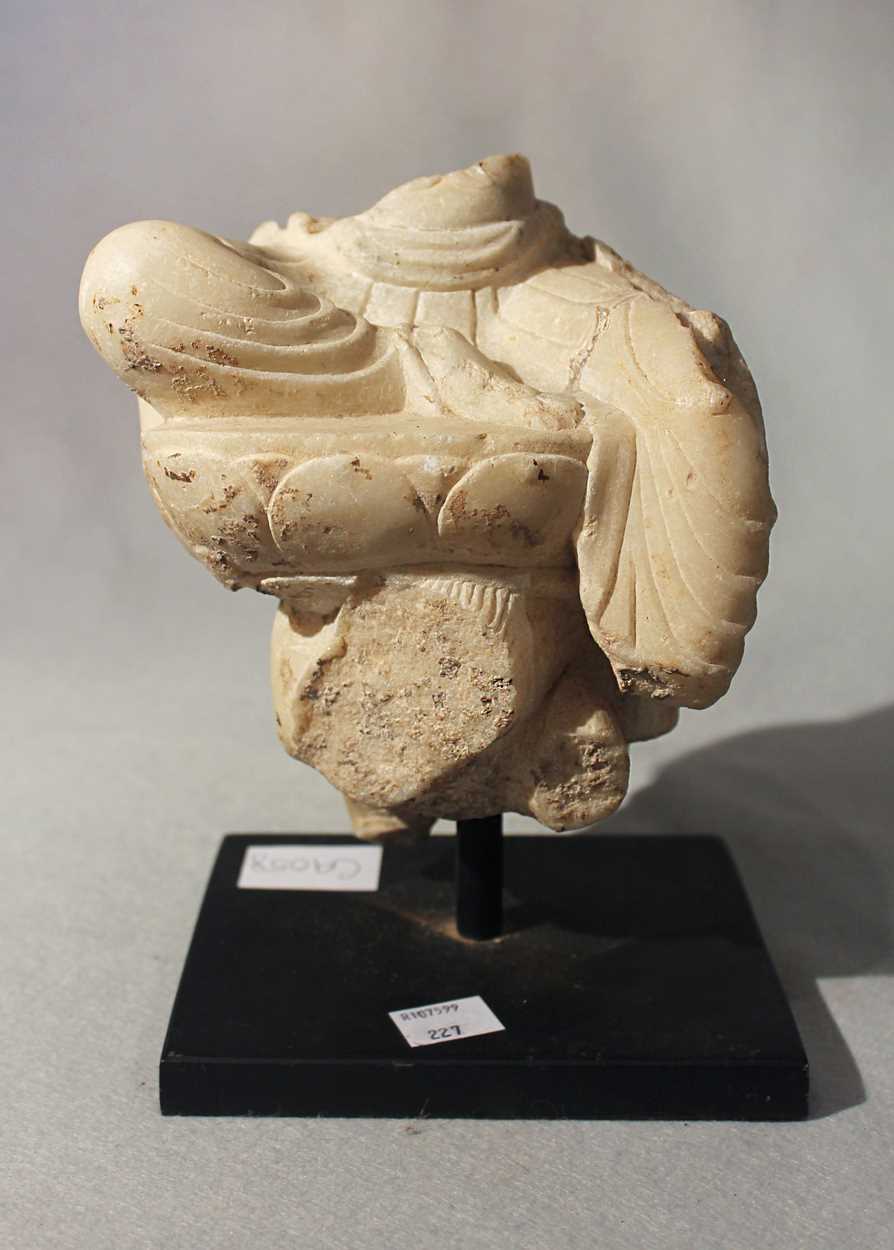 Lot 289 - A white marble fragment of a deity on lotus dais on horseback, in Tang style
