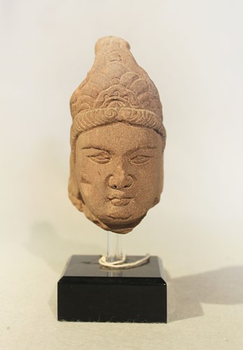 Lot 128 - A red sandstone head of a Bodhisattva,...