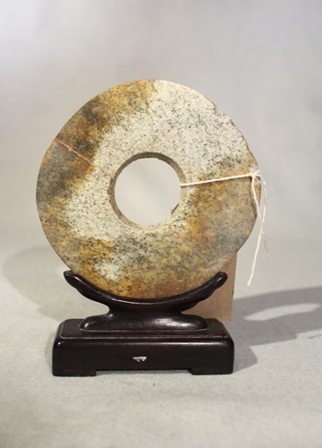 Lot 135 - A Chinese chicken bone jade bi disc in...
