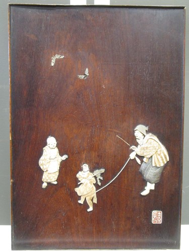 Lot 157 - A Japanese wooden panel inlaid with ivory and...