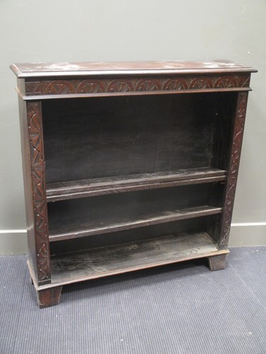 Lot 579 - Am oak four shelf bookcase, the frieze carved...