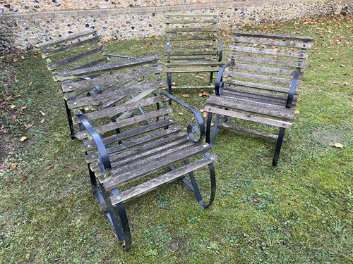 Lot 559 - A set of four wrought iron garden chairs with...